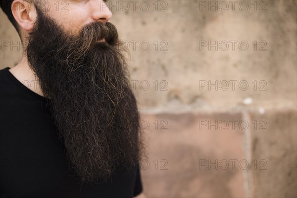 Close up bearded young man against wall