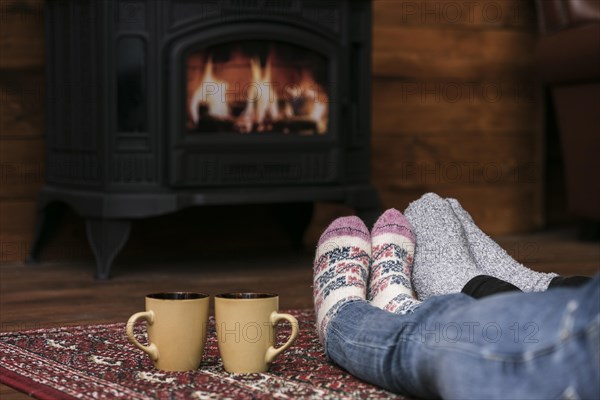 Couples warming feet fireplace