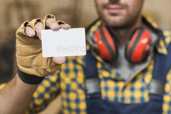 Male carpenter showing blank white visiting card