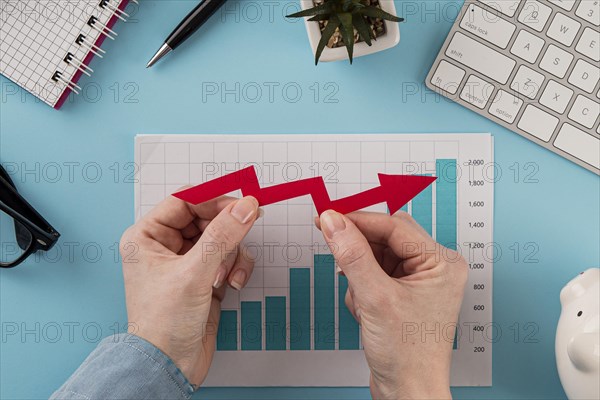 Top view business items with growth chart hands holding arrow