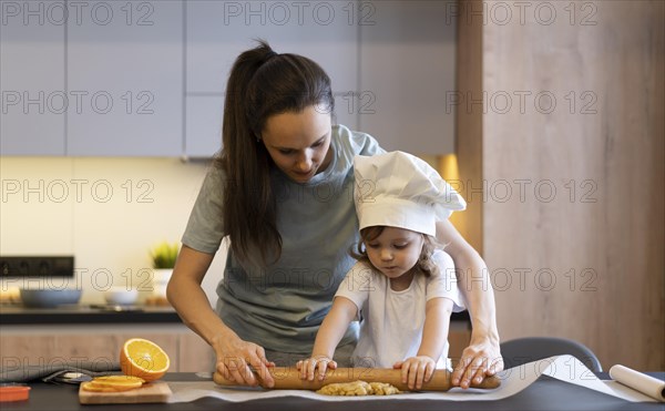 Medium shot mother kid using rolling pin