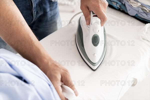 Hands ironing clothes close up
