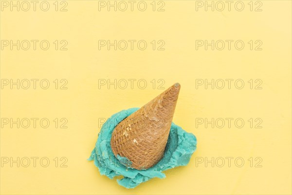 Blue ice cream cone falling yellow background