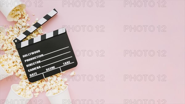 Top view cinema clapperboard with popcorn