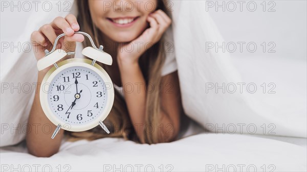 Smiley girl holding white clock