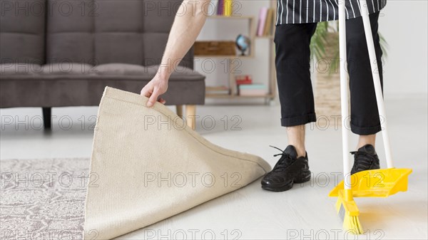 Close up man brooming floor