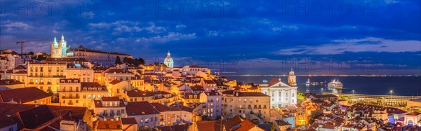 Panorama of Lisbon famous view from Miradouro de Santa Luzia tourist viewpoint over Alfama old city district at night. Lisbon