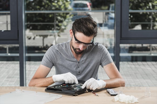 Young male technician repairing computer workshop