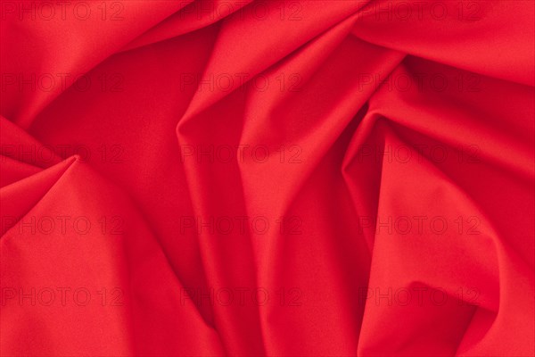 Folded red textile fabric texture background