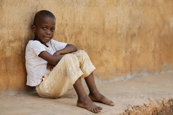 Full shot kid sitting outdoors