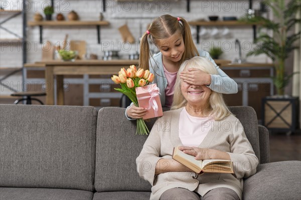 Granddaughter covering her grandmother s eyes