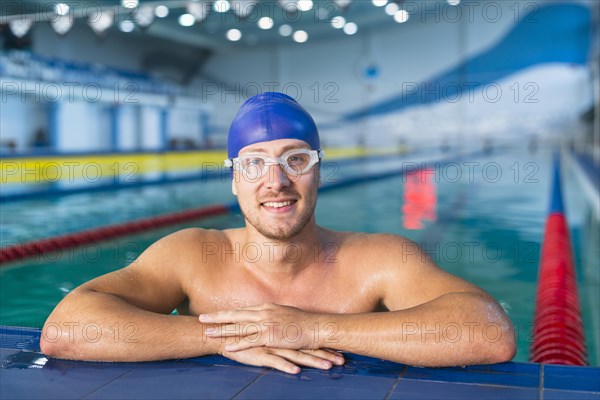 Male swimmer standing edge pool