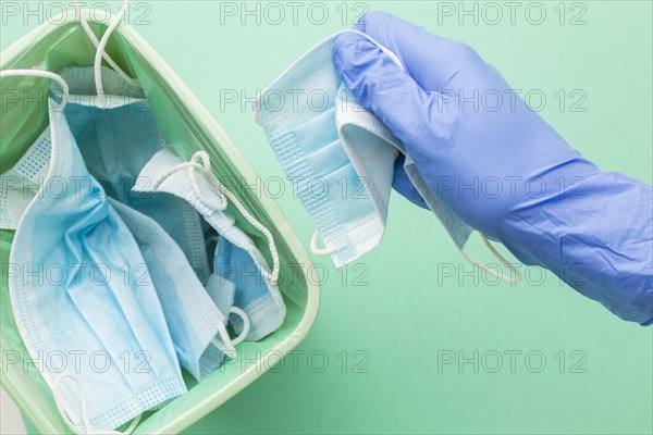 Person wearing protection gloves taking disposable mask