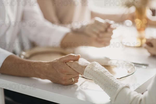 Beautiful family praying before eating close up