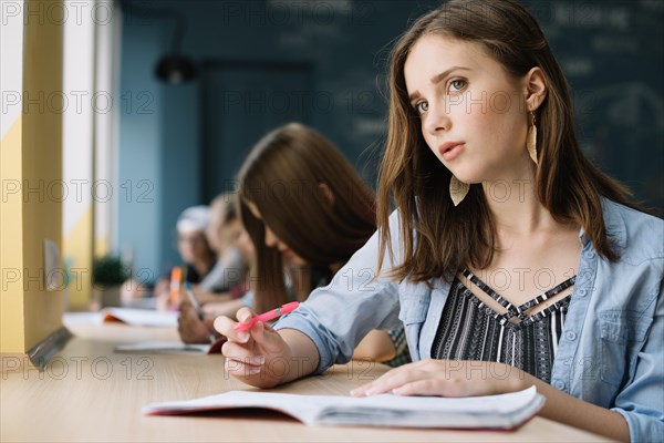 Thinking schoolgirl looking camera