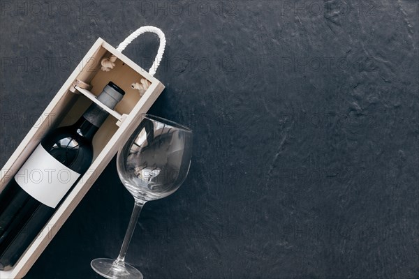 Empty glass near box with wine