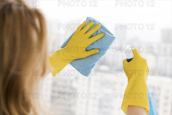 Woman cleaning window with rag