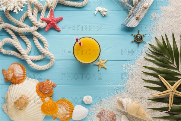 Flat lay juice glass surrounded by beach elements