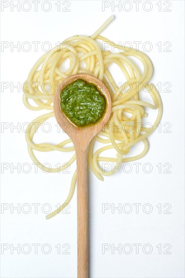 Pesto in cooking spoon and spaghetti