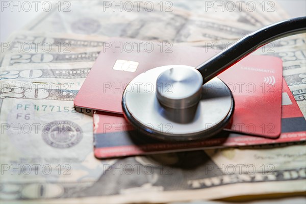 Stethoscope with bank notes and credit card. Stethoscope on credit card with dollar bills