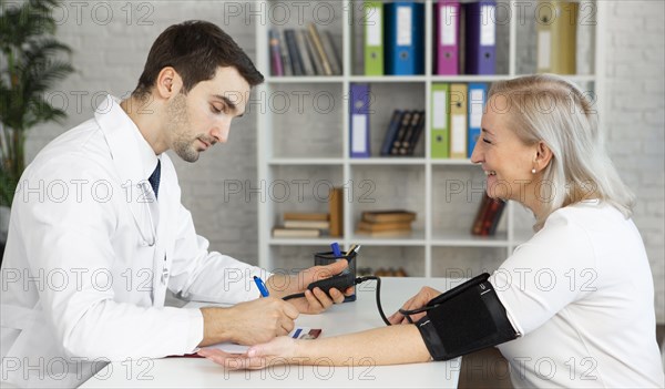 Medium shot doctor taking blood pressure