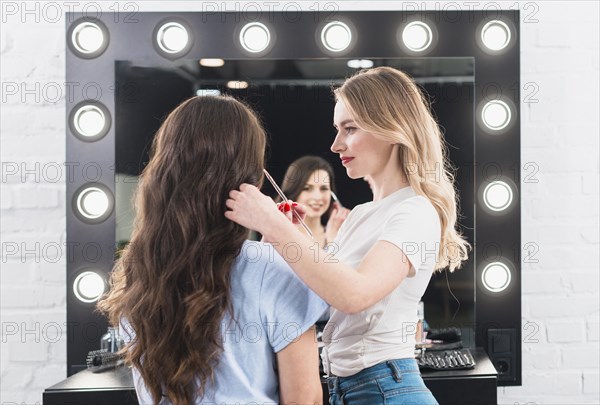 Blonde doing eye makeup client with brush