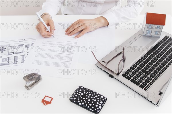 Overhead view human hand putting signature official paper office
