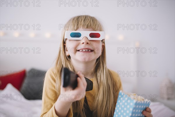 Cheerful girl watching tv bedroom