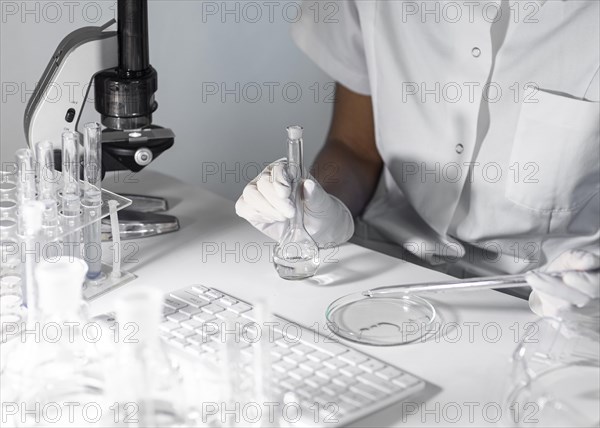 Close up scientist holding glassware