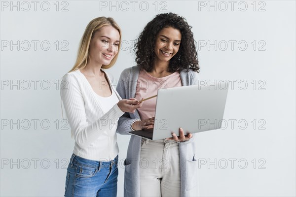 Smiling ethnic woman blond coworker with gray laptop