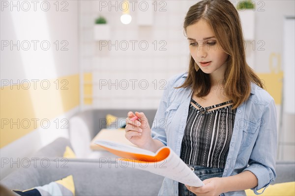 Concentrated girl posing with textbook