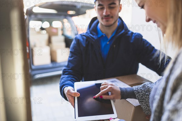 Woman giving online signature deliveryman