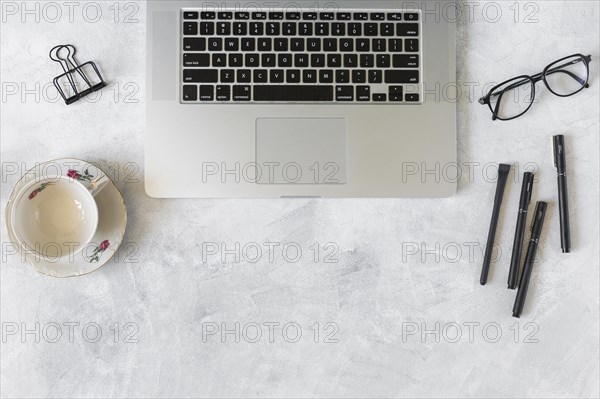 Laptop near eyeglasses cup dish