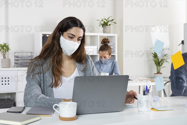 Medium shot woman working laptop