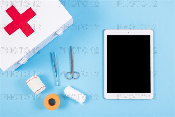 Medical equipments with first aid kit blank digital tablet blue background