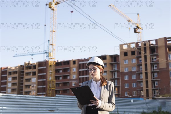 Professional female architecture writing clipboard construction site