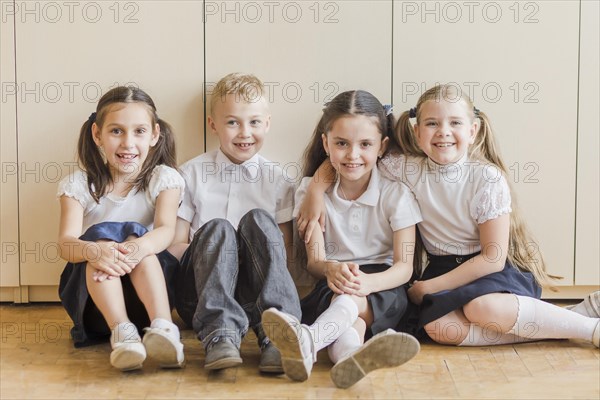 Cheerful kids sitting floor school