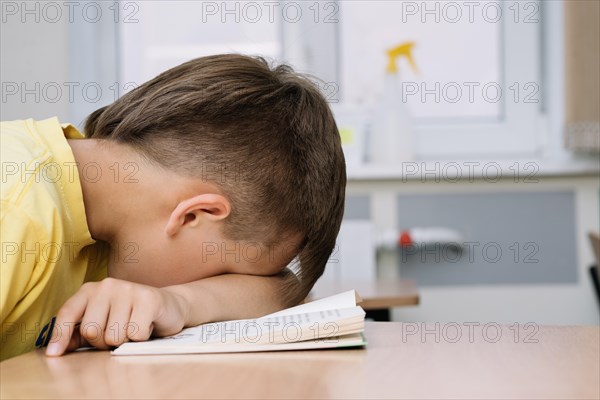 Boy sleeping leaning table