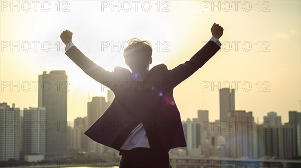 Excited businessman celebrates with his fists in the air with the city in the background