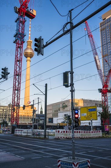 Construction cranes in front of television tower