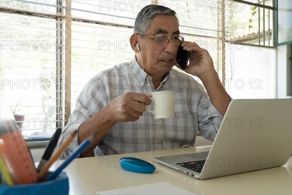 Man using smartphone in home office