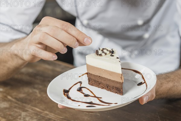 Male pastry chef decorating dessert kitchen