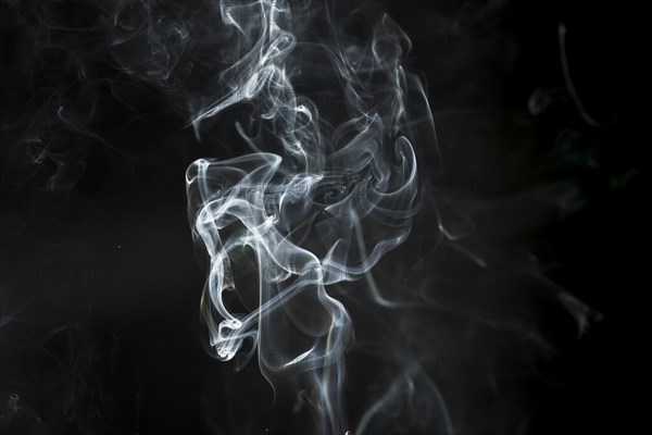 Dark background with delicate white smoke