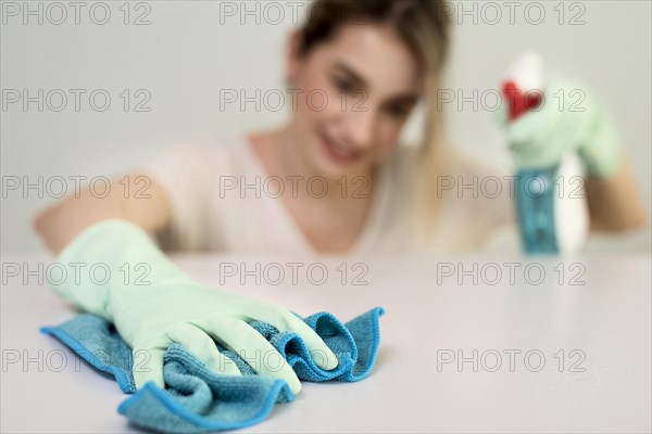 Defocused woman with gloves cleaning surface