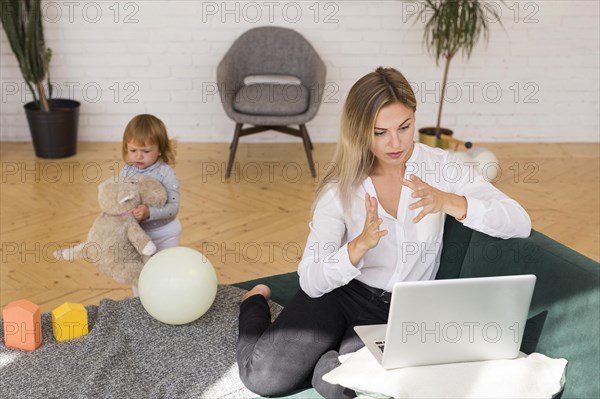 Full shot mother working from home