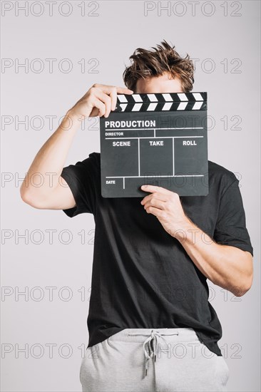 Man hiding his face clapperboard