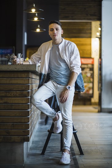 Modern young man with glass whiskey bar counter