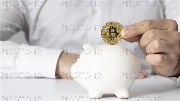 Man inserting bitcoin piggy bank