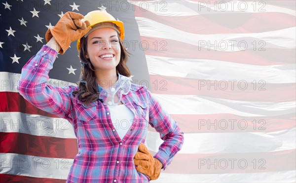 Female contractor wearing blank yellow hardhat and gloves over waving american flag background banner