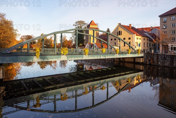 Autumnal coloured trees with iron bridge over the river Maltsch with the city wall of the historical old town of Ceske Budejovice